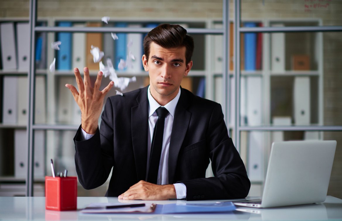 businesman throwing torn, crumpled contract over his shoulder