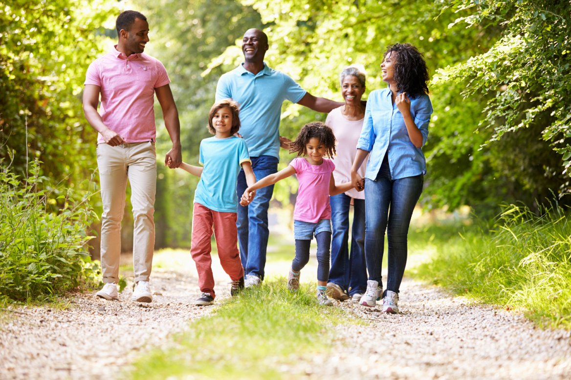 multigenerational family walking on wooded path