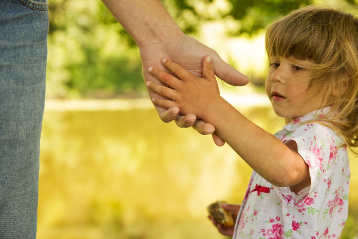 parent and child reach to hold hands