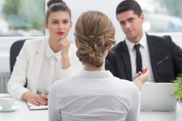 woman and man conducting a job interview with a young woman